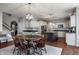 Open concept floor plan showing the kitchen, dining area, and staircase with wood floors and elegant lighting at 6649 Braemar S Ave, Noblesville, IN 46062