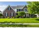Beautiful brick two-story home with manicured lawn, decorative trees, and black shutters at 6649 Braemar S Ave, Noblesville, IN 46062