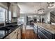 Gourmet kitchen with granite counters, stainless sink, hardwood floors, and an open view of the dining and living areas at 6649 Braemar S Ave, Noblesville, IN 46062