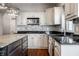 Bright kitchen featuring white cabinets, stainless steel appliances and dark countertops and kitchen island at 6649 Braemar S Ave, Noblesville, IN 46062
