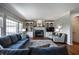 Comfortable living room featuring a fireplace, built-in shelving, and large windows at 6649 Braemar S Ave, Noblesville, IN 46062