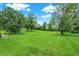 Large backyard with lush green grass and mature trees at 6838 Five Points Rd, Indianapolis, IN 46259
