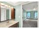 Bathroom leading into carpeted bedroom, featuring a vintage vanity and mirror at 6838 Five Points Rd, Indianapolis, IN 46259