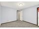 A spacious bedroom features neutral walls and carpet, with a door to another room enhancing the home's open feel at 6838 Five Points Rd, Indianapolis, IN 46259