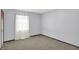 A cozy bedroom is painted a light blue and features neutral carpeting and a window with curtains at 6838 Five Points Rd, Indianapolis, IN 46259