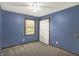 Bedroom with blue walls, carpet floors, and a window with blinds at 6838 Five Points Rd, Indianapolis, IN 46259