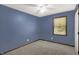 Bedroom with blue walls, white ceiling fan, carpet floor, and window with trim at 6838 Five Points Rd, Indianapolis, IN 46259