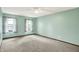 A bright bedroom with neutral carpeting and two windows offers serene space with a ceiling fan at 6838 Five Points Rd, Indianapolis, IN 46259