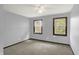 A bright bedroom with two windows provides natural light, enhancing the space's neutral paint and carpeting at 6838 Five Points Rd, Indianapolis, IN 46259