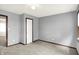 A spacious bedroom with gray walls and carpeting features a side door and a window with blinds at 6838 Five Points Rd, Indianapolis, IN 46259