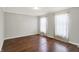 A bright bedroom with hardwood floors, neutral walls, and natural light from the airy windows at 6838 Five Points Rd, Indianapolis, IN 46259