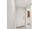 Hallway with a white door and an open doorway looking into a bathroom at 6838 Five Points Rd, Indianapolis, IN 46259