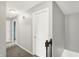 Hallway with grey walls, white trim, carpeted floor, and white doors at 6838 Five Points Rd, Indianapolis, IN 46259