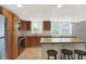 Traditional kitchen features wood cabinets, tile floors, and a butcher block breakfast bar with three wooden bar stools at 6838 Five Points Rd, Indianapolis, IN 46259