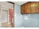 The laundry area, featuring wood cabinets and blue walls, is next to a bathroom at 6838 Five Points Rd, Indianapolis, IN 46259