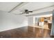 Open concept living room, connecting the kitchen, with wood floors, ceiling beams, and a ceiling fan at 6838 Five Points Rd, Indianapolis, IN 46259