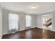 Bright living room with hardwood floors, neutral walls, two large windows, and a doorway with stairs at 6838 Five Points Rd, Indianapolis, IN 46259