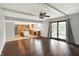Open concept living room with kitchen, wood floors, ceiling beams, and sliding glass door at 6838 Five Points Rd, Indianapolis, IN 46259