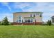 The exterior shot of a two-story home features a tan exterior with a well-kept lawn and clear sky at 7046 Allegiance Ct, Indianapolis, IN 46259