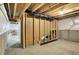Unfinished basement with exposed wooden beams, wrapped walls, and doorway to potential living space at 7046 Allegiance Ct, Indianapolis, IN 46259