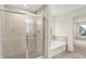 Bathroom featuring tiled shower with glass doors and soaking tub with tiled surround at 7046 Allegiance Ct, Indianapolis, IN 46259