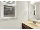Well-lit powder room with a vanity, sink, and a window with blinds at 7046 Allegiance Ct, Indianapolis, IN 46259