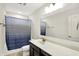 Well-lit bathroom features a vanity with a large mirror and a shower with decorative curtain at 7046 Allegiance Ct, Indianapolis, IN 46259