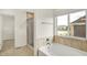 Bathroom with soaking tub, tiled surround, and walk-in closet with views of neighborhood at 7046 Allegiance Ct, Indianapolis, IN 46259