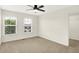 Bright bedroom with neutral walls, carpet, and a ceiling fan, illuminated by natural light from two windows at 7046 Allegiance Ct, Indianapolis, IN 46259