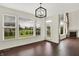 Dining area featuring large windows, hardwood floors, and a view into the adjacent living space with a fireplace at 7046 Allegiance Ct, Indianapolis, IN 46259