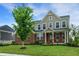 Attractive two-story house with manicured lawn, vibrant flowers, and inviting front porch at 7046 Allegiance Ct, Indianapolis, IN 46259