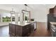 A kitchen with stainless steel appliances, granite countertops, dark wood cabinets, and views of the fireplace and backyard at 7046 Allegiance Ct, Indianapolis, IN 46259