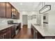 A kitchen with stainless steel appliances, granite countertops, dark wood cabinets, and a spacious island at 7046 Allegiance Ct, Indianapolis, IN 46259