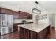 A spacious kitchen is complete with stainless steel appliances, dark wood cabinets and an island with granite countertops at 7046 Allegiance Ct, Indianapolis, IN 46259