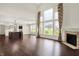 Spacious living room with hardwood floors, fireplace, and large windows offering scenic views and natural light at 7046 Allegiance Ct, Indianapolis, IN 46259