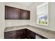 A walk-in pantry features granite countertops, dark wood cabinets, and natural light from the window at 7046 Allegiance Ct, Indianapolis, IN 46259