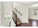 Bright foyer with a staircase featuring carpeted steps and a dark wood handrail leading to the upper level at 7046 Allegiance Ct, Indianapolis, IN 46259