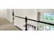 Staircase with carpeted steps and wood railing, leading to an open hallway at 7046 Allegiance Ct, Indianapolis, IN 46259