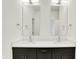 Bathroom vanity featuring double sinks, modern fixtures, and a sleek, dark cabinet at 727 N Illinois St # 202, Indianapolis, IN 46204