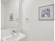 Clean powder room featuring a pedestal sink, modern faucet, and neutral decor at 727 N Illinois St # 202, Indianapolis, IN 46204