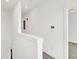 Bright upper hallway with neutral carpet, white walls, and a thermostat at 727 N Illinois St # 202, Indianapolis, IN 46204