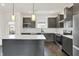 Stylish kitchen with stainless steel appliances, gray cabinets, quartz counters and island seating at 727 N Illinois St # 202, Indianapolis, IN 46204