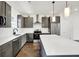 Modern kitchen features stainless steel appliances, gray cabinetry, and a center island with white countertops at 727 N Illinois St # 202, Indianapolis, IN 46204