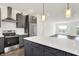 A modern kitchen showcases stainless steel appliances, grey cabinets, and a quartz island with seating at 727 N Illinois St # 202, Indianapolis, IN 46204