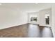 Spacious living room with dark wood floors, white walls, and a balcony door at 727 N Illinois St # 202, Indianapolis, IN 46204