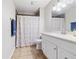 Bathroom with single sink vanity, standard toilet, and shower with flower curtain at 7319 Jackie Ct, Indianapolis, IN 46221
