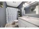 Cozy bathroom with stylish vanity, tile floor, and shower with patterned curtain at 7319 Jackie Ct, Indianapolis, IN 46221