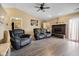Comfortable living room featuring a fireplace, ceiling fan, and vinyl floors at 7319 Jackie Ct, Indianapolis, IN 46221