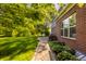 The backyard features a stone walkway through the green grass and a view of mature trees at 734 Richland Way, Westfield, IN 46074