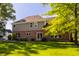 Home's backyard has mature trees, a brick exterior, and lush landscaping for outdoor enjoyment at 734 Richland Way, Westfield, IN 46074